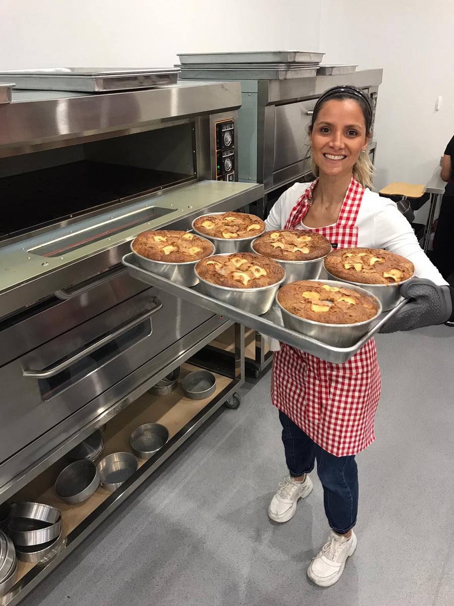 Helena, founder and baker at Cozy Cake, with a tray of fresh cakes